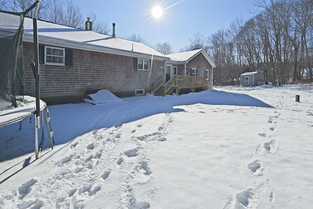 exterior space with a storage shed, a deck, and an outbuilding