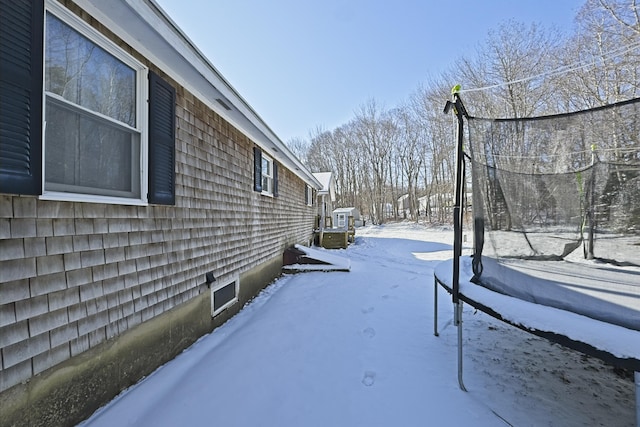 snowy yard featuring a trampoline