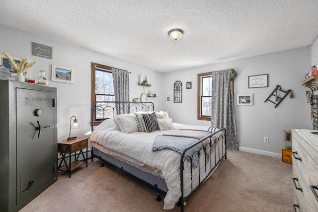 bedroom featuring baseboard heating, light carpet, a textured ceiling, and baseboards