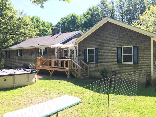 18 Trunnel Ln, Friendship, ME 04547 - back of property with a wooden deck, a yard, a covered pool, and a chimney