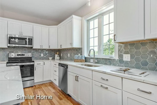 170 Buttonbush Ln Unit 21, Wells, ME 04090 - kitchen with appliances with stainless steel finishes, a sink, white cabinets, and tasteful backsplash
