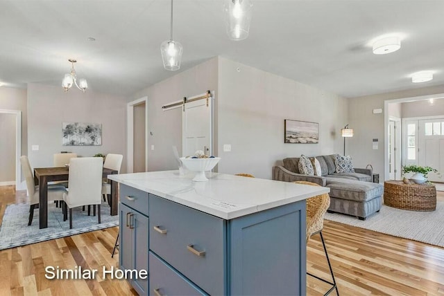 170 Buttonbush Ln Unit 21, Wells, ME 04090 - kitchen featuring a barn door, a breakfast bar area, light wood finished floors, and a center island