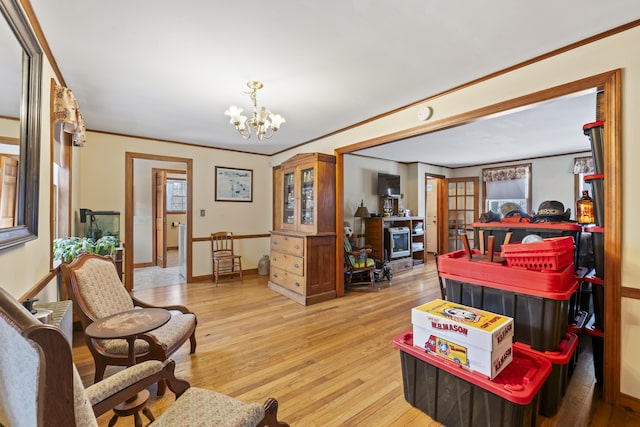 living room featuring a notable chandelier, crown molding, and light wood-type flooring