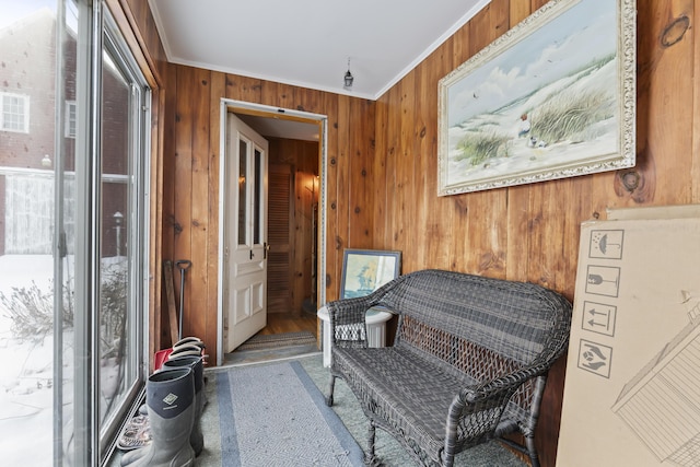 sitting room with crown molding and wooden walls