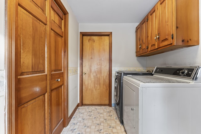 washroom featuring cabinets and washing machine and clothes dryer