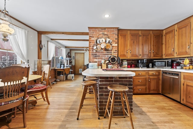 kitchen with a center island, stainless steel appliances, a breakfast bar, and light wood-type flooring