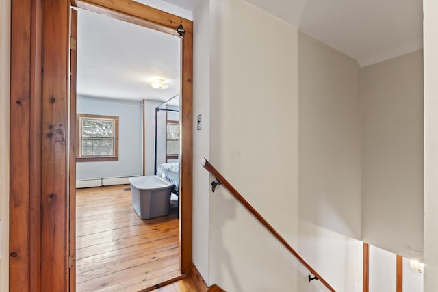 stairway with hardwood / wood-style flooring and a baseboard radiator