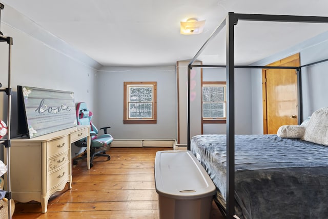 bedroom with baseboard heating and light hardwood / wood-style flooring