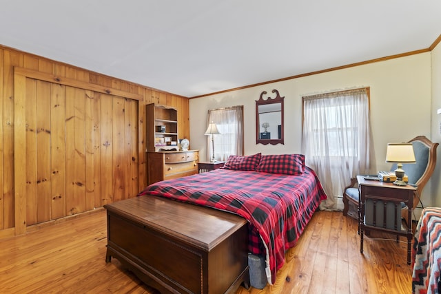 bedroom with multiple windows, light hardwood / wood-style flooring, and ornamental molding