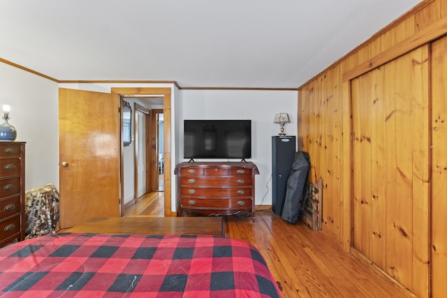 bedroom featuring ornamental molding and light hardwood / wood-style floors