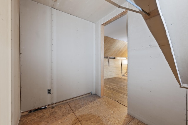 hallway featuring wooden walls