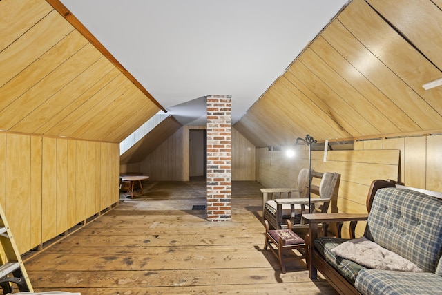 additional living space with lofted ceiling, hardwood / wood-style flooring, decorative columns, wooden ceiling, and wood walls