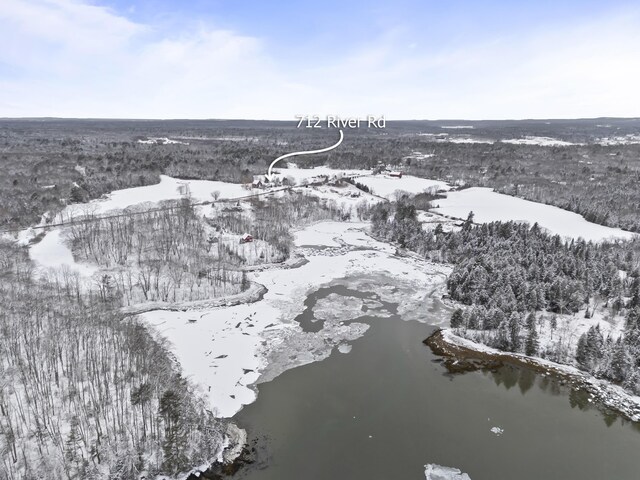 snowy aerial view featuring a water view