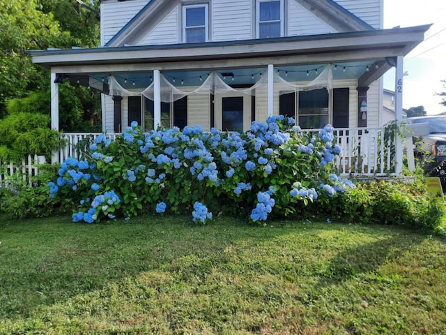 view of home's exterior featuring covered porch, a chimney, and a lawn