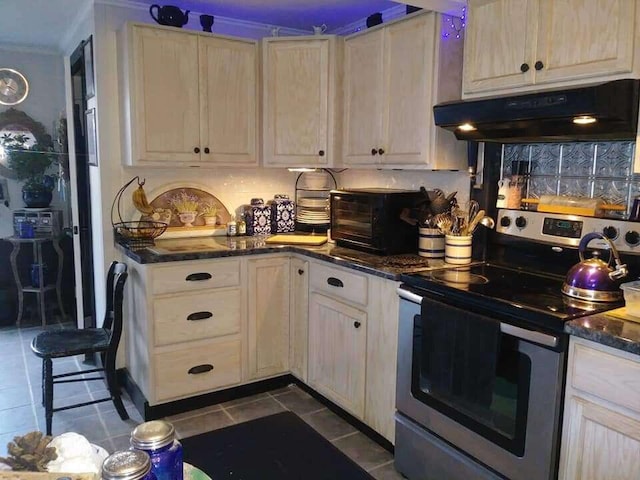 kitchen featuring a toaster, under cabinet range hood, stainless steel electric stove, dark tile patterned floors, and tasteful backsplash