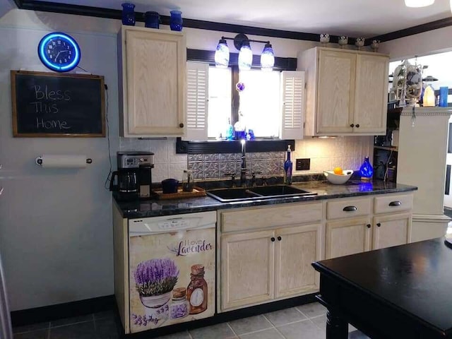 kitchen featuring light tile patterned floors, white dishwasher, dark countertops, and a sink