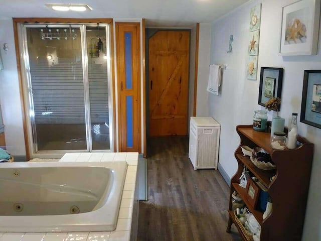 full bath with wood finished floors, a jetted tub, and a shower stall