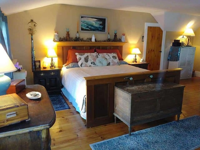 bedroom with vaulted ceiling and hardwood / wood-style floors