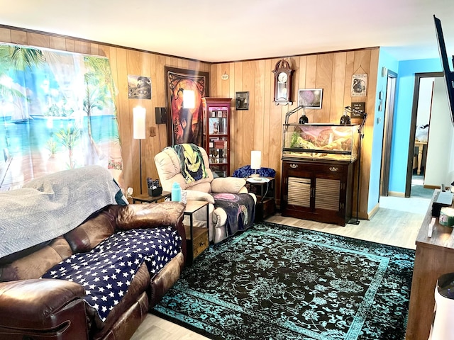 living room featuring wooden walls, baseboards, and wood finished floors