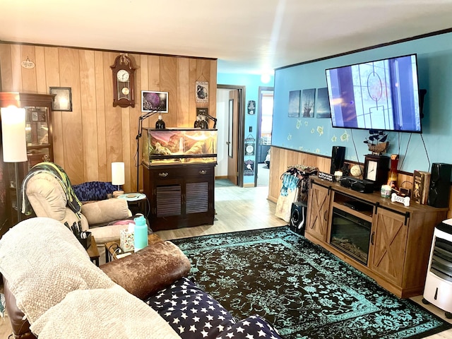 living area with light wood-type flooring and wooden walls