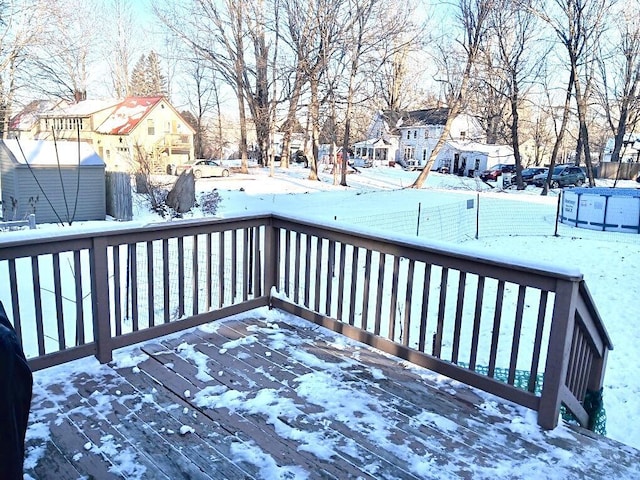 snow covered deck with a residential view