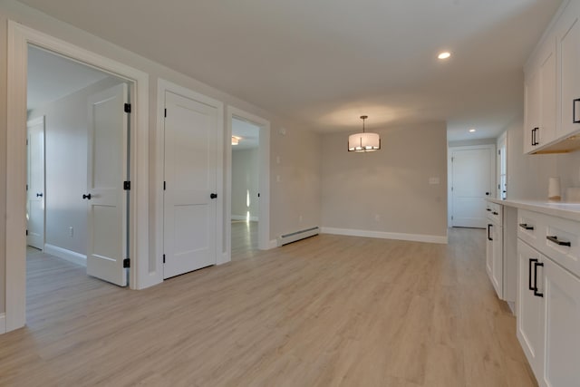 interior space with light hardwood / wood-style floors and baseboard heating