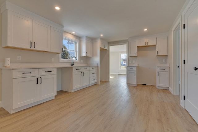 kitchen featuring light wood-type flooring and white cabinetry