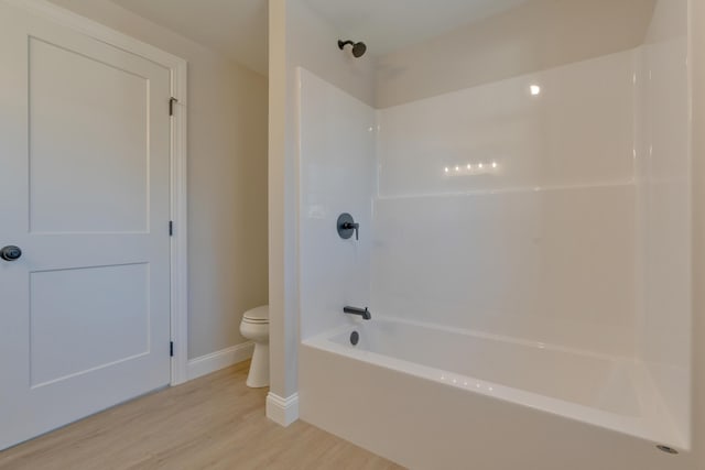 bathroom with toilet, shower / bath combination, and hardwood / wood-style flooring