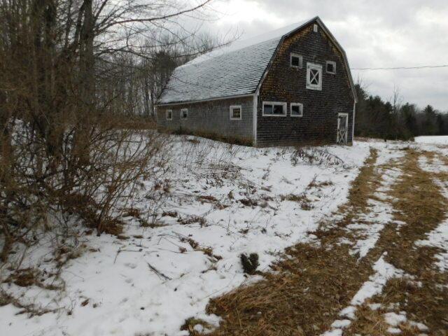 snow covered property with an outbuilding