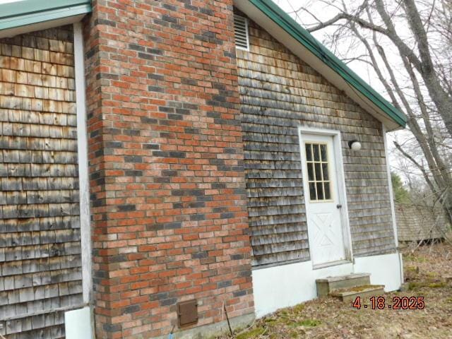 view of side of property featuring entry steps and brick siding