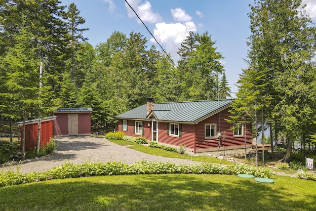 view of front of home with a front lawn and a storage shed