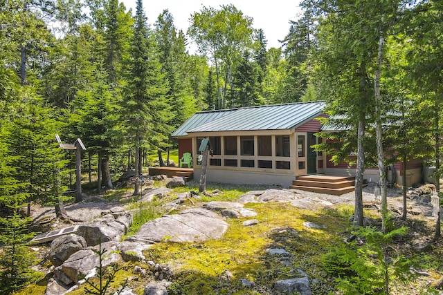 back of property with a sunroom