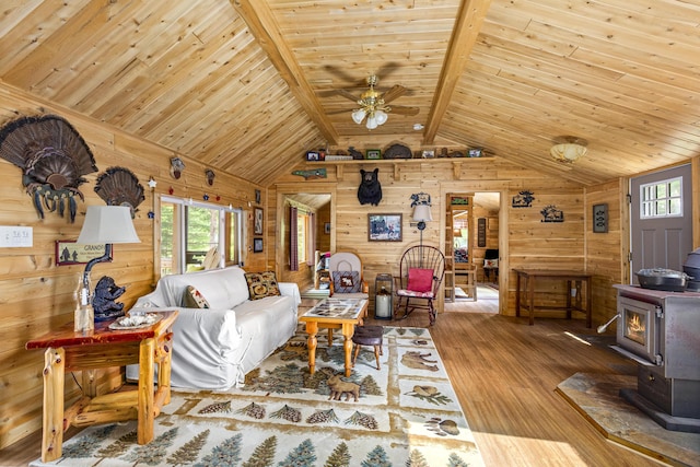 living room featuring a wood stove, wooden walls, wooden ceiling, and hardwood / wood-style flooring