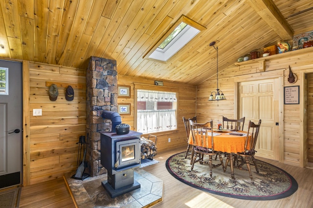 dining area with wood ceiling, lofted ceiling with skylight, and hardwood / wood-style floors