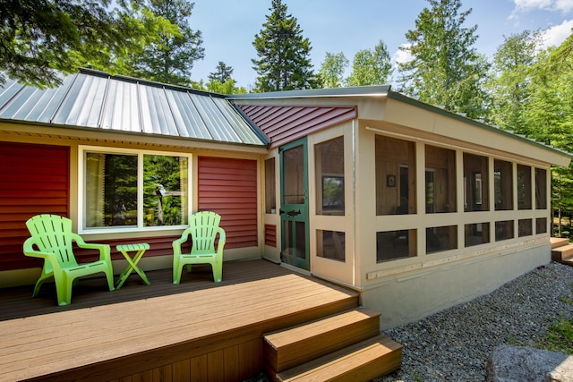 back of house with a wooden deck and a sunroom
