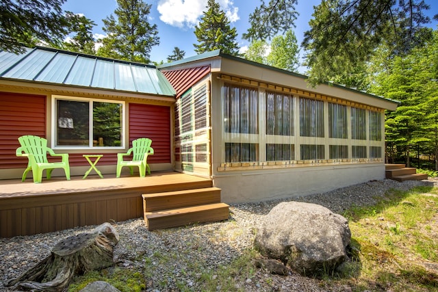 rear view of property with a deck and a sunroom