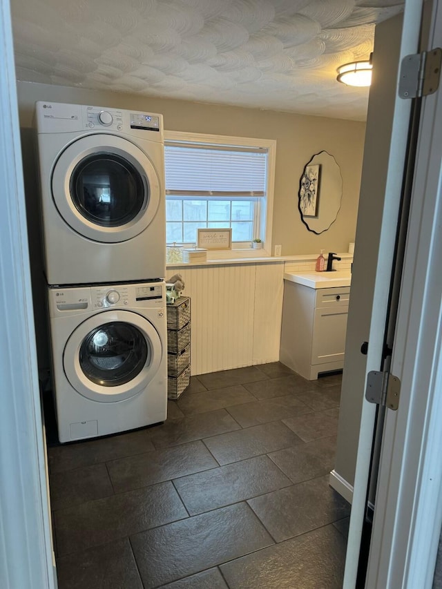 clothes washing area featuring stacked washer / drying machine