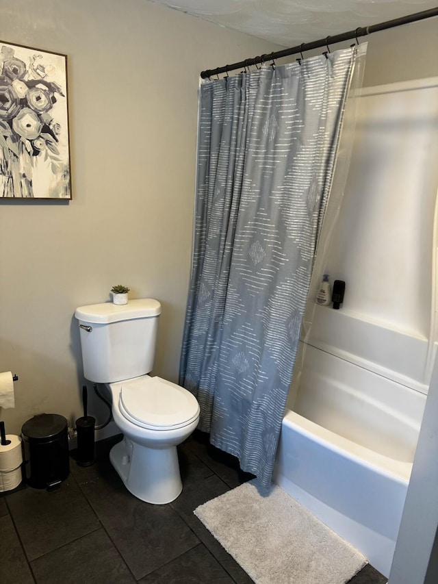 bathroom with tile patterned floors, shower / bath combination with curtain, and toilet