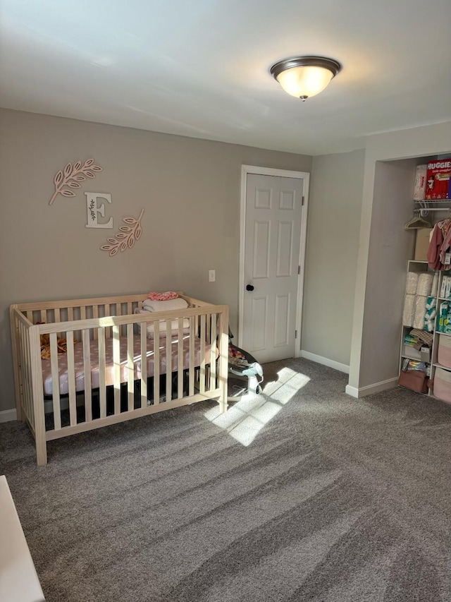 carpeted bedroom featuring a nursery area and a closet