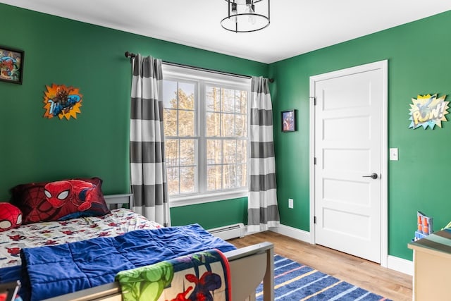 bedroom featuring hardwood / wood-style floors and baseboard heating