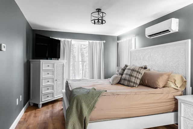 bedroom featuring multiple windows, a wall mounted AC, and dark hardwood / wood-style flooring