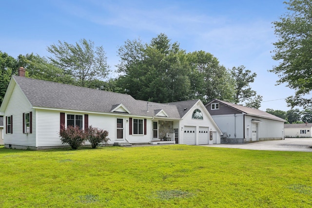 view of front facade with driveway, a shingled roof, and a front yard