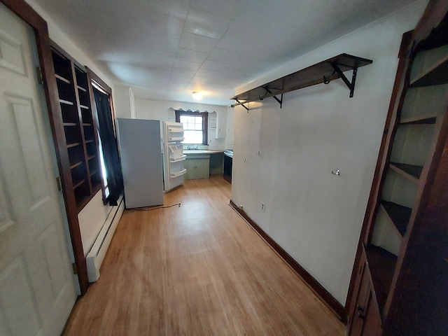 interior space with sink, light wood-type flooring, and a baseboard heating unit