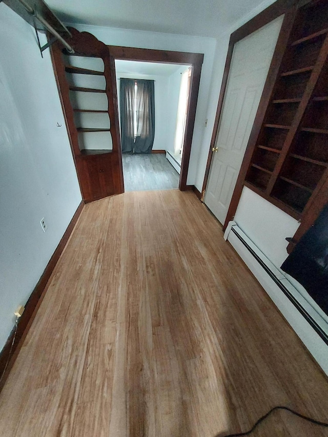 interior space featuring wood-type flooring and a baseboard heating unit