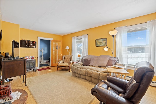 living room with baseboard heating and light hardwood / wood-style floors