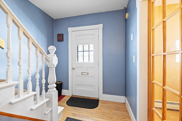 foyer entrance with hardwood / wood-style flooring and a baseboard radiator