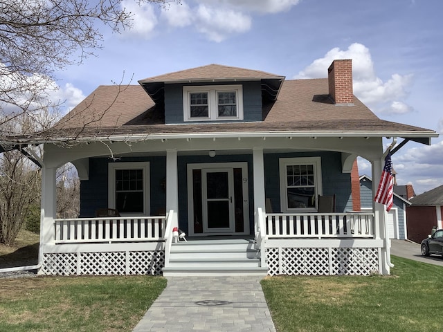 bungalow featuring a porch and a front lawn