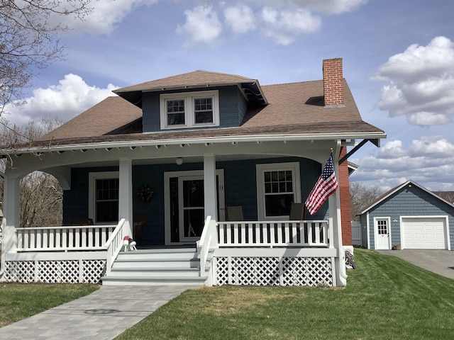 bungalow-style house featuring a front yard, a porch, a chimney, an outdoor structure, and a detached garage