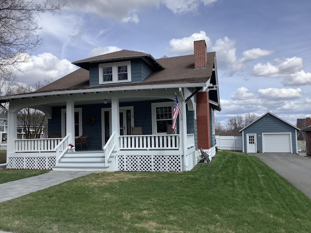 bungalow-style home with an outbuilding, covered porch, a chimney, a front lawn, and a garage