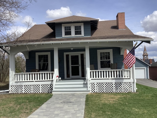 bungalow featuring a chimney, an outbuilding, a porch, and a front yard